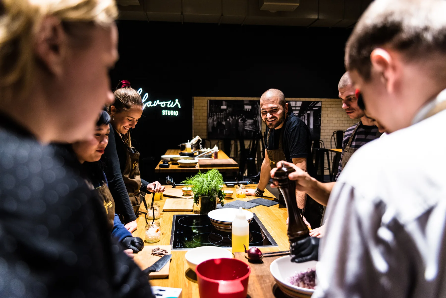 Tiimi kokkaa yhdessä Flavour Studion saarekkeella.